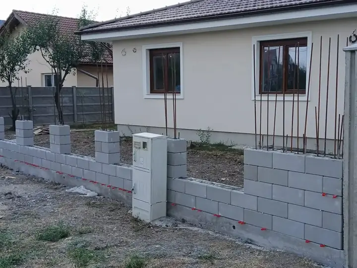 Zsalukő kerítés lábazat és pillérek építés közben kiálló betonacél vasalással