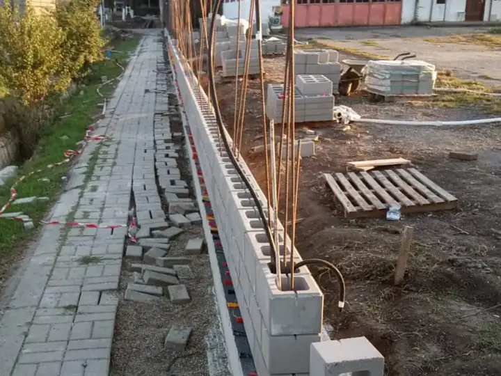 Zsalukő sor falazása függőleges vasalással járda mentén, zsalukő kerítés építése